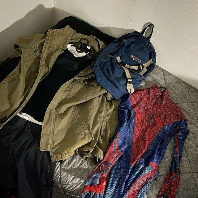 MaskOryx navy blue and tan Peter Parker TASM1 replica backpack displayed with a jacket and Spider-Man costume